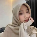 Young Malay escort girl in KL, wearing a hijab, looking thoughtful
