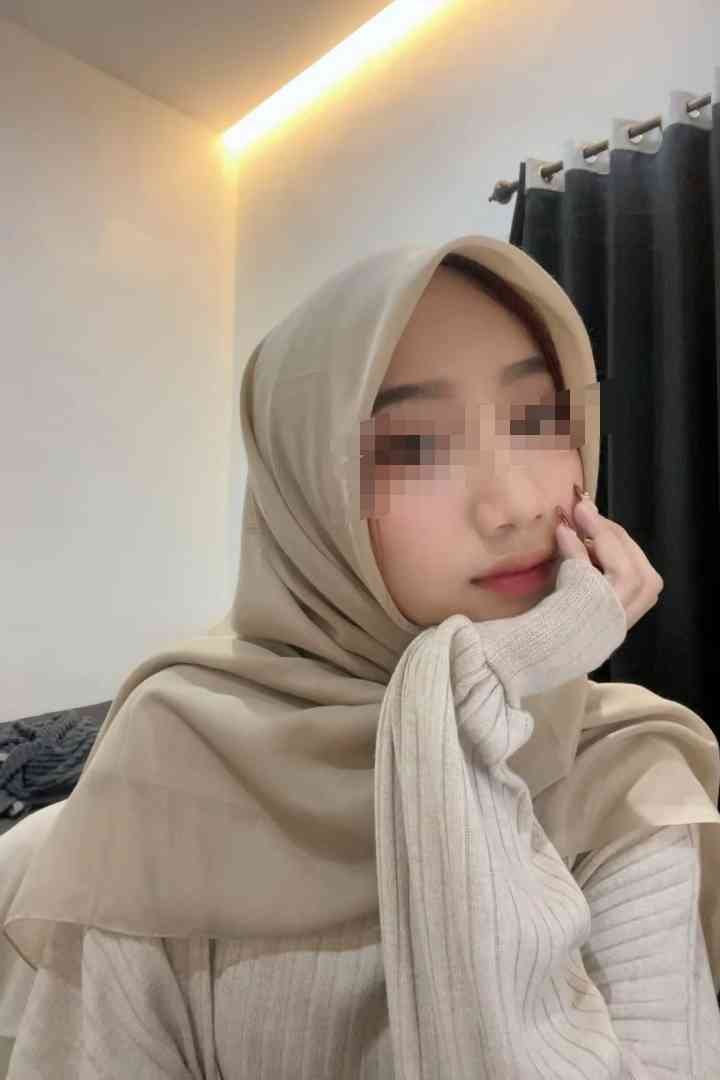 Young Malay escort girl in KL, wearing a hijab, looking thoughtful