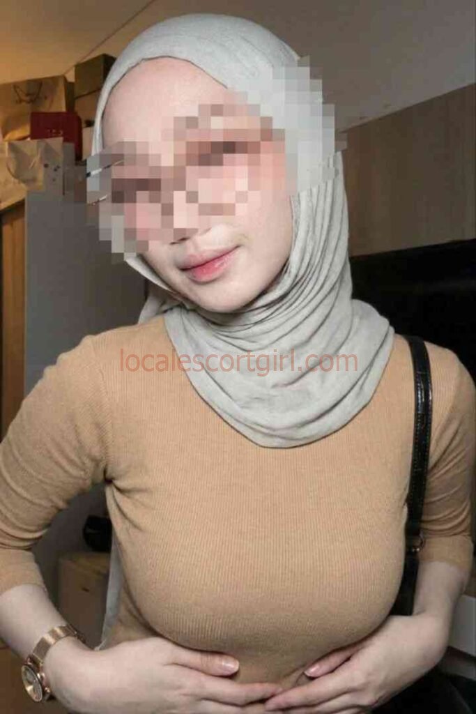 Kesya in a beige top and hijab, smiling
